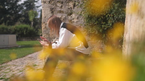 Mujer-Alérgica-Estornuda-Mientras-Se-Relaja-En-El-Parque-Cerca-De-Flores-En-Flor